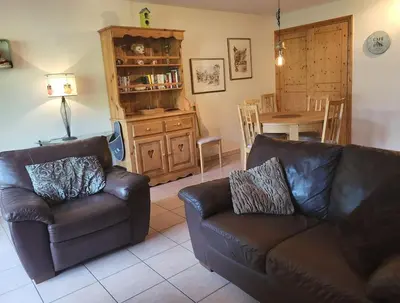 a living room with two leather couches and a table at A1/2, 3 bedroom apartment next to the ski lift in Samoëns