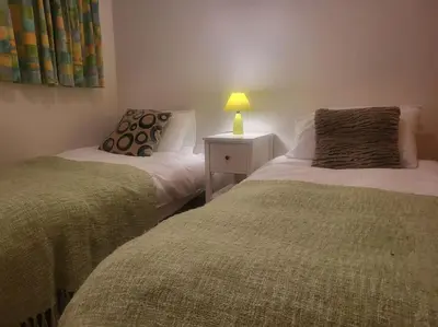 a bedroom with two beds and a lamp on a night stand at A1/2, 3 bedroom apartment next to the ski lift in Samoëns