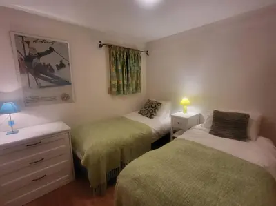 a bedroom with two beds and a dresser with a lamp at A1/2, 3 bedroom apartment next to the ski lift in Samoëns