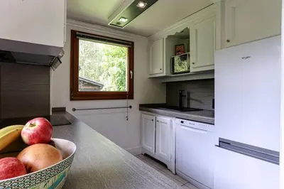 a kitchen with a bowl of fruit on a counter at chalet l'ilet ensoleillé /Sunny Island Chalet in Chamonix-Mont-Blanc