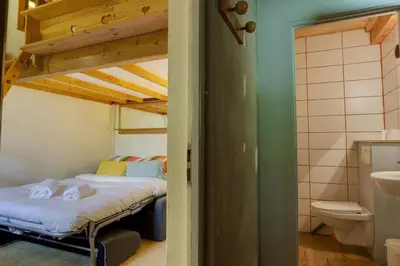 a bedroom with two bunk beds and a bathroom at chalet l'ilet ensoleillé /Sunny Island Chalet in Chamonix-Mont-Blanc