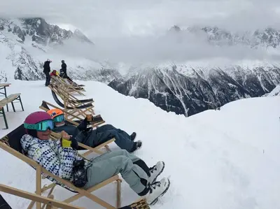 two people sitting in chairs on a snow covered mountain at chalet l'ilet ensoleillé /Sunny Island Chalet in Chamonix-Mont-Blanc