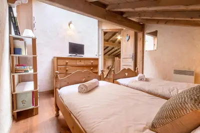 a bedroom with two beds and a tv in it at Les Cristalliers - Cozy family chalet - Close to the village in Les Houches