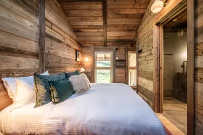 a bedroom in a log cabin with a bed at Apartment Tourmalet Carrôz d'Arâches - BY EMERALD STAY in Les Carroz d'Araches