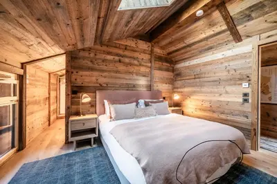 a bedroom with a large bed in a wooden room at Apartment Tourmalet Carrôz d'Arâches - BY EMERALD STAY in Les Carroz d'Araches