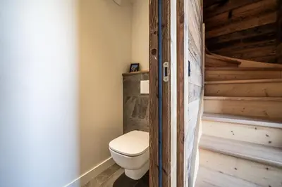 a bathroom with a toilet in a log cabin at Apartment Tourmalet Carrôz d'Arâches - BY EMERALD STAY in Les Carroz d'Araches