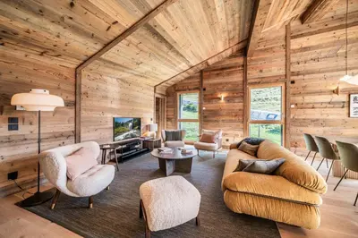 a living room with wooden walls and furniture in a house at Apartment Tourmalet Carrôz d'Arâches - BY EMERALD STAY in Les Carroz d'Araches