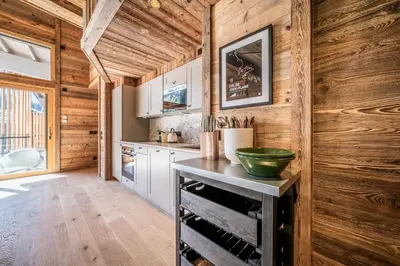 a kitchen with wooden walls and a table with a green bowl at Apartment Tourmalet Carrôz d'Arâches - BY EMERALD STAY in Les Carroz d'Araches