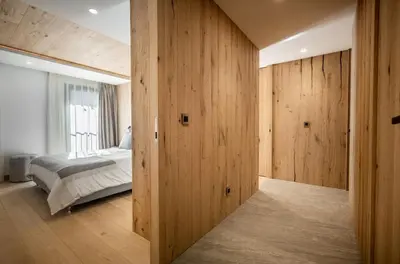 a bedroom with wooden walls and a bed and a window at L'Ecrin Blanc Megève in Megève
