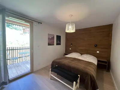 a bedroom with a bed and a large window at Superbe appart 3P au pied des pistes, parking couvert, terrasse, WiFi - Les Carroz - FR-1-572-288 in Arâches-la-Frasse