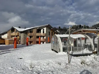 a building with a tent in the snow at Superbe appart 3P au pied des pistes, parking couvert, terrasse, WiFi - Les Carroz - FR-1-572-288 in Arâches-la-Frasse