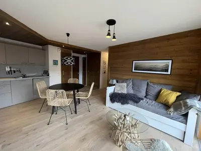 a living room with a couch and a table at Superbe appart 3P au pied des pistes, parking couvert, terrasse, WiFi - Les Carroz - FR-1-572-288 in Arâches-la-Frasse