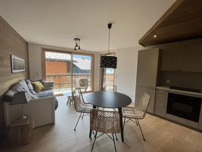 a kitchen and living room with a table and chairs at Superbe appart 3P au pied des pistes, parking couvert, terrasse, WiFi - Les Carroz - FR-1-572-288 in Arâches-la-Frasse