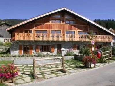 a large wooden house with a fence in front of it at Appartement 3 pièces - 6 pers - Proche pistes et commerces, navette gratuite - FR-1-572-19 in Arâches-la-Frasse