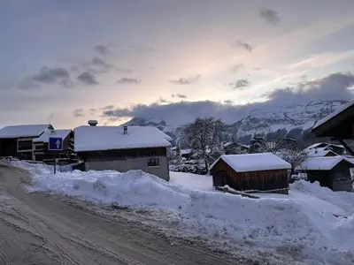 a snow covered village with buildings and a dirt road at Appartement 3 pièces - 6 pers - Proche pistes et commerces, navette gratuite - FR-1-572-19 in Arâches-la-Frasse