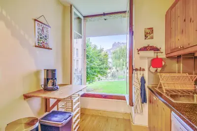 a kitchen with a window and a table and a counter at Appartement Yodel - Welkeys in Saint-Gervais-les-Bains