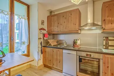 a kitchen with wooden cabinets and a stove top oven at Appartement Yodel - Welkeys in Saint-Gervais-les-Bains
