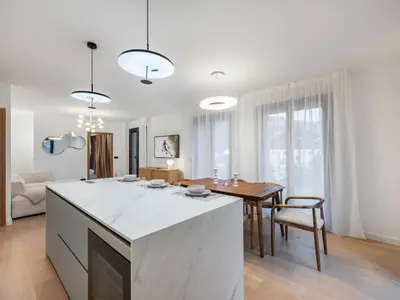 a white kitchen with a table and a dining room at Spacieux appartement moderne à Megève, 6 personnes - FR-1-569-129 in Megève
