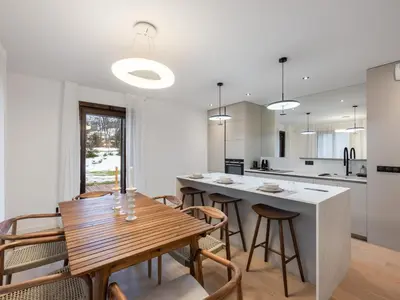 a kitchen and dining room with a wooden table and chairs at Spacieux appartement moderne à Megève, 6 personnes - FR-1-569-129 in Megève
