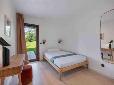 a bedroom with a bed and a desk and a television at Spacieux appartement moderne à Megève, 6 personnes - FR-1-569-129 in Megève