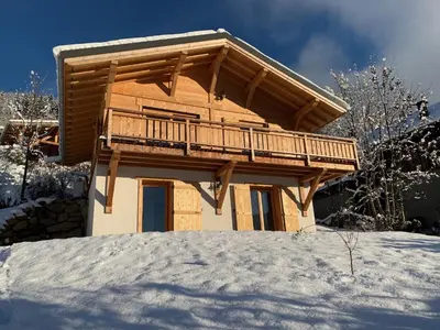 a log cabin with a balcony in the snow at Chalet le jardin de fées in Saint-Gervais-les-Bains