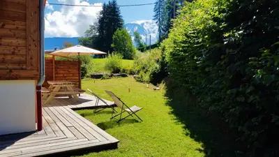 a patio with a table and chairs and an umbrella at Chalet à Saint-Gervais-les-Bains, 8 personnes, 4 chambres in Saint-Gervais-les-Bains