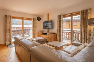 a living room with a couch and a large window at Grand Paradis- Modern 3 bedroom apartment with spectacular views in Chamonix-Mont-Blanc