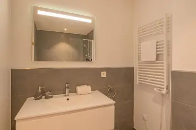 a bathroom with a sink and a mirror at Grand Paradis- Modern 3 bedroom apartment with spectacular views in Chamonix-Mont-Blanc