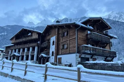 a large wooden building with snow on it at Grand Paradis- Modern 3 bedroom apartment with spectacular views in Chamonix-Mont-Blanc