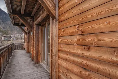 a wooden walkway leading to a porch on a log cabin at Grand Paradis- Modern 3 bedroom apartment with spectacular views in Chamonix-Mont-Blanc