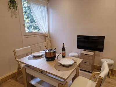 a dining room with a table and a television at Le Mont Bohème in Saint-Gervais-les-Bains