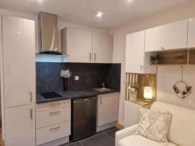 a kitchen with white cabinets and a sink and a chair at Le Mont Bohème in Saint-Gervais-les-Bains