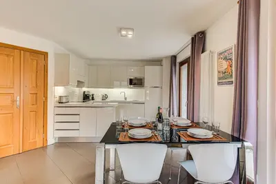 a kitchen with a table with white chairs and a counter top at Apartment Alpes IV - Alpes Travel - Central Chamonix (sleeps 4) in Chamonix-Mont-Blanc