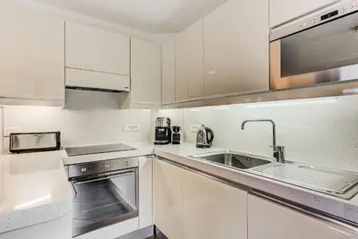 a kitchen with white cabinets and a sink at Apartment Alpes IV - Alpes Travel - Central Chamonix (sleeps 4) in Chamonix-Mont-Blanc