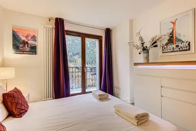 a bedroom with a bed and a window at Apartment Alpes IV - Alpes Travel - Central Chamonix (sleeps 4) in Chamonix-Mont-Blanc