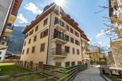 a building with the mountains in the background at Apartment Alpes IV - Alpes Travel - Central Chamonix (sleeps 4) in Chamonix-Mont-Blanc