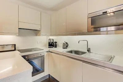 a kitchen with white cabinets and a sink at Apartment Alpes IV - Alpes Travel - Central Chamonix (sleeps 4) in Chamonix-Mont-Blanc
