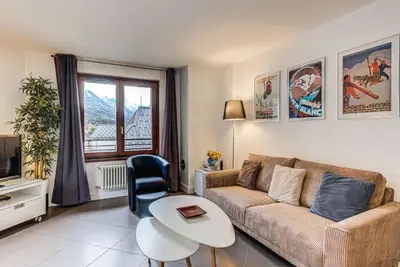 a living room with a couch and a table at Apartment Alpes IV - Alpes Travel - Central Chamonix (sleeps 4) in Chamonix-Mont-Blanc