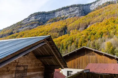 two buildings with a mountain in the background at Gîte des Cascades in Sixt