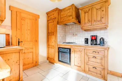 a kitchen with wooden cabinets and a stove at Gîte des Cascades in Sixt