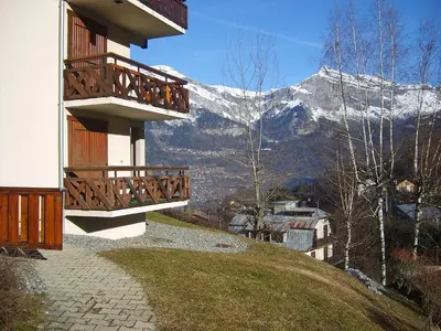 a hotel with a snow covered mountain in the background at Apartment Les Hauts de Saint Gervais-11 by Interhome in Saint-Gervais-les-Bains