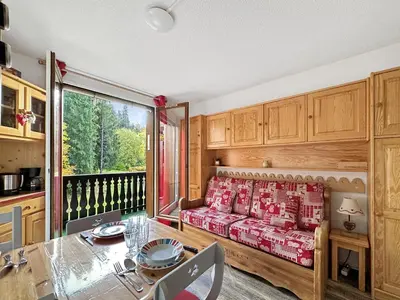 a living room with a couch and a table and a window at gc462 studio 4 pers proche skibus in Les Carroz d'Araches