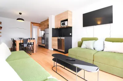 a living room with a couch and a table at Stunning 4-bedroom apartment Flaine Foret, fully refurbished, beautiful panoramic views in Flaine
