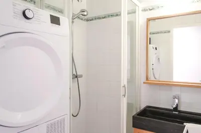 a bathroom with a washing machine and a sink at Stunning 4-bedroom apartment Flaine Foret, fully refurbished, beautiful panoramic views in Flaine