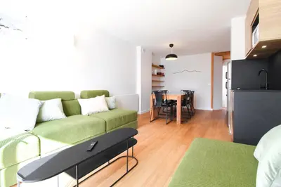 a living room with a green couch and a table at Stunning 4-bedroom apartment Flaine Foret, fully refurbished, beautiful panoramic views in Flaine