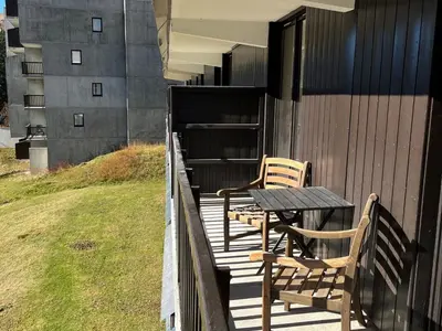 two chairs and a table on a wooden deck at Appartement lumineux · Centre station · 6 pers · Balcon · WI-FI - FR-1-425-205 in Arâches-la-Frasse