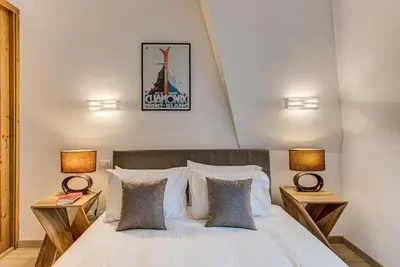 a bedroom with a white bed with two lamps at Apartment Alpes V - Alpes Travel - Central Chamonix - Sleeps 5 in Chamonix-Mont-Blanc