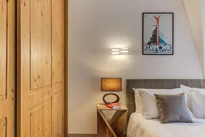 a bedroom with a bed and a night stand with a lamp at Apartment Alpes V - Alpes Travel - Central Chamonix - Sleeps 5 in Chamonix-Mont-Blanc
