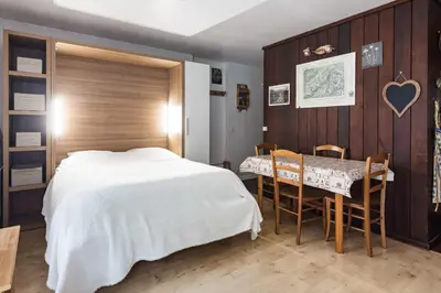 a bedroom with a bed and a table and chairs at Studio - Le Vorasson Ideal for a duo break in Saint-Gervais! in Saint-Gervais-les-Bains