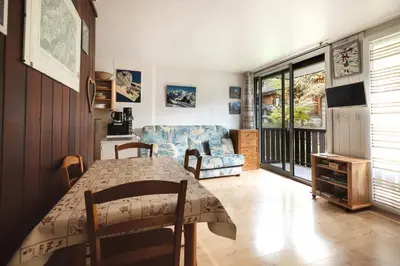 a living room with a table and a couch at Studio - Le Vorasson Ideal for a duo break in Saint-Gervais! in Saint-Gervais-les-Bains